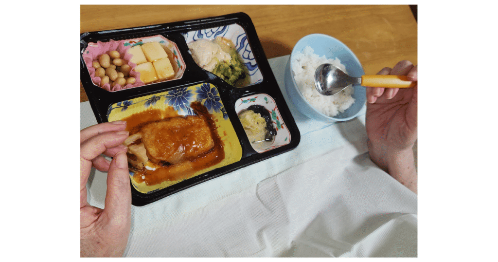 ご飯と食楽膳のお弁当に手をつけようとしてる写真